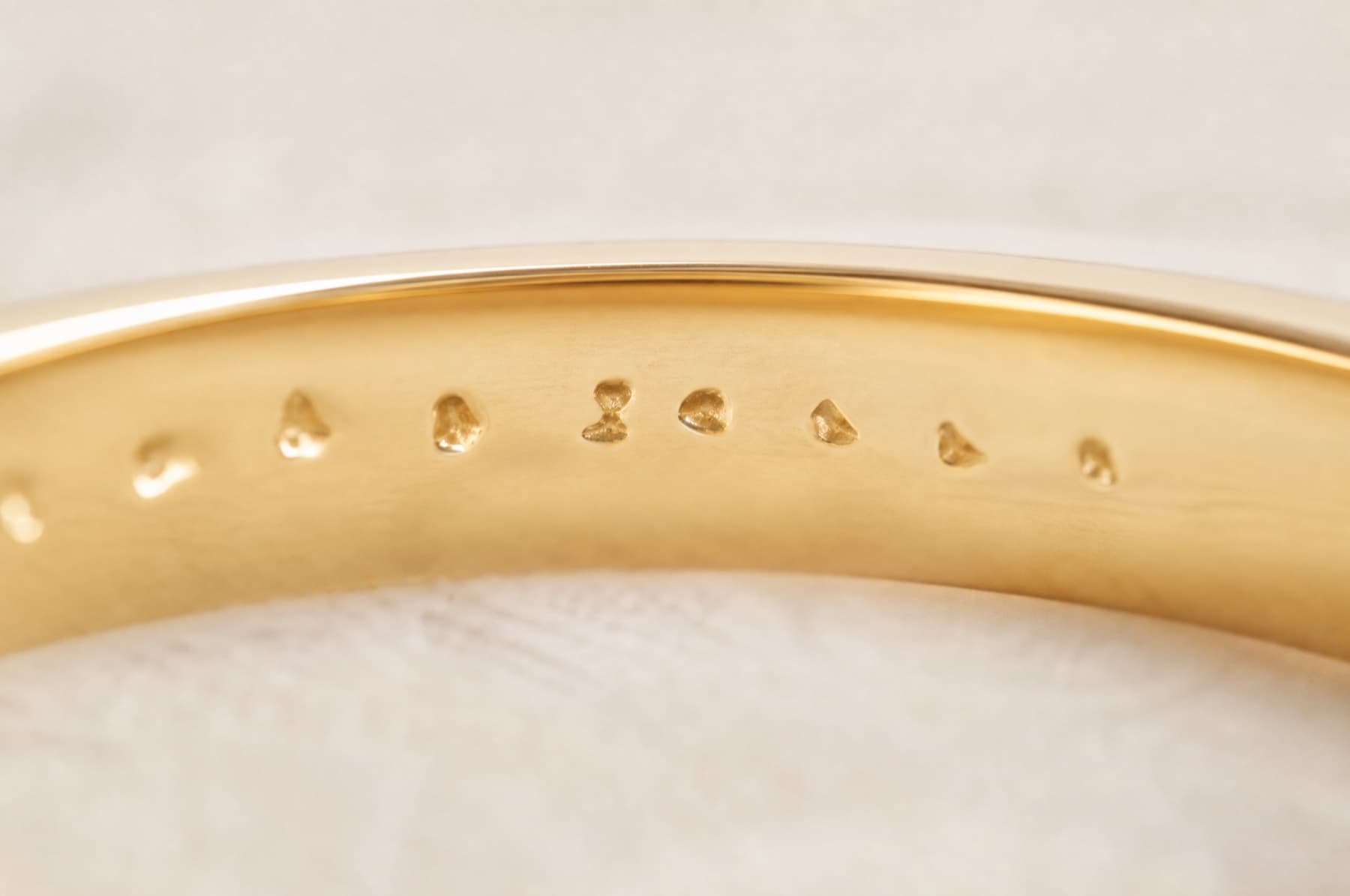 The inside of a gold band, showing the row of struck marks